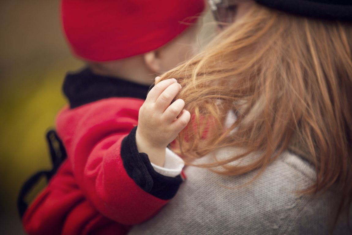 Kind fährt durch Haare seiner Mutter