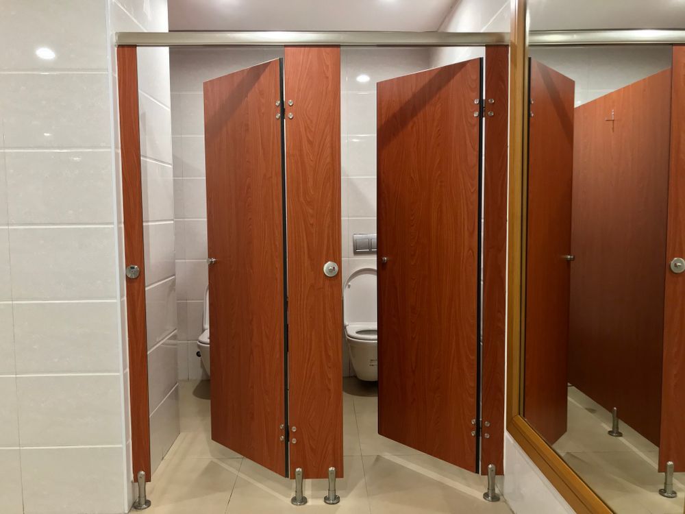 A Public Restroom With Wooden Cubicles And A Toilet — Roo’s Door & Window Maintenance In Sippy Downs, QLD