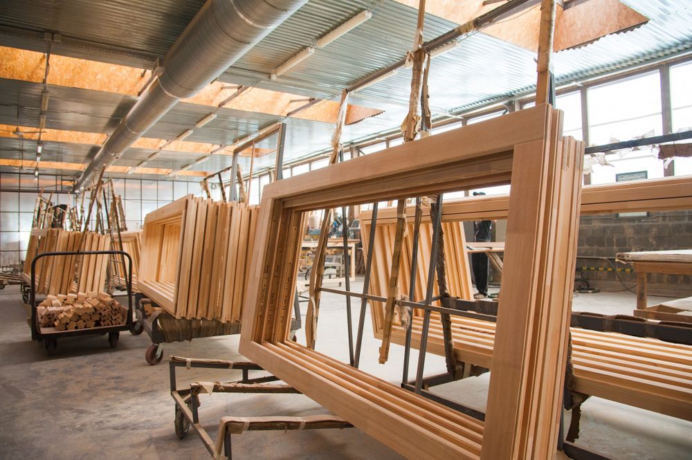 A Warehouse Filled With Lots Of Wooden Frames — Roo’s Door & Window Maintenance In Sippy Downs, QLD