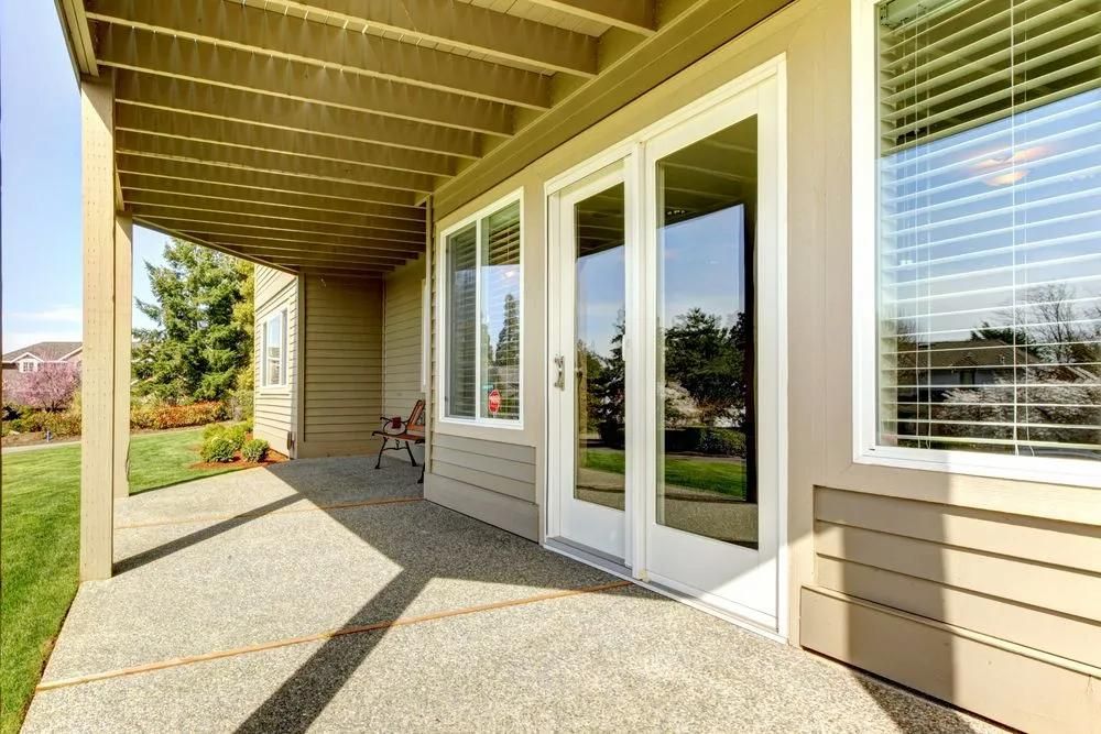 There is a Patio With Sliding Glass Doors and a Pergola — Roo’s Door & Window Maintenance In Sippy Downs