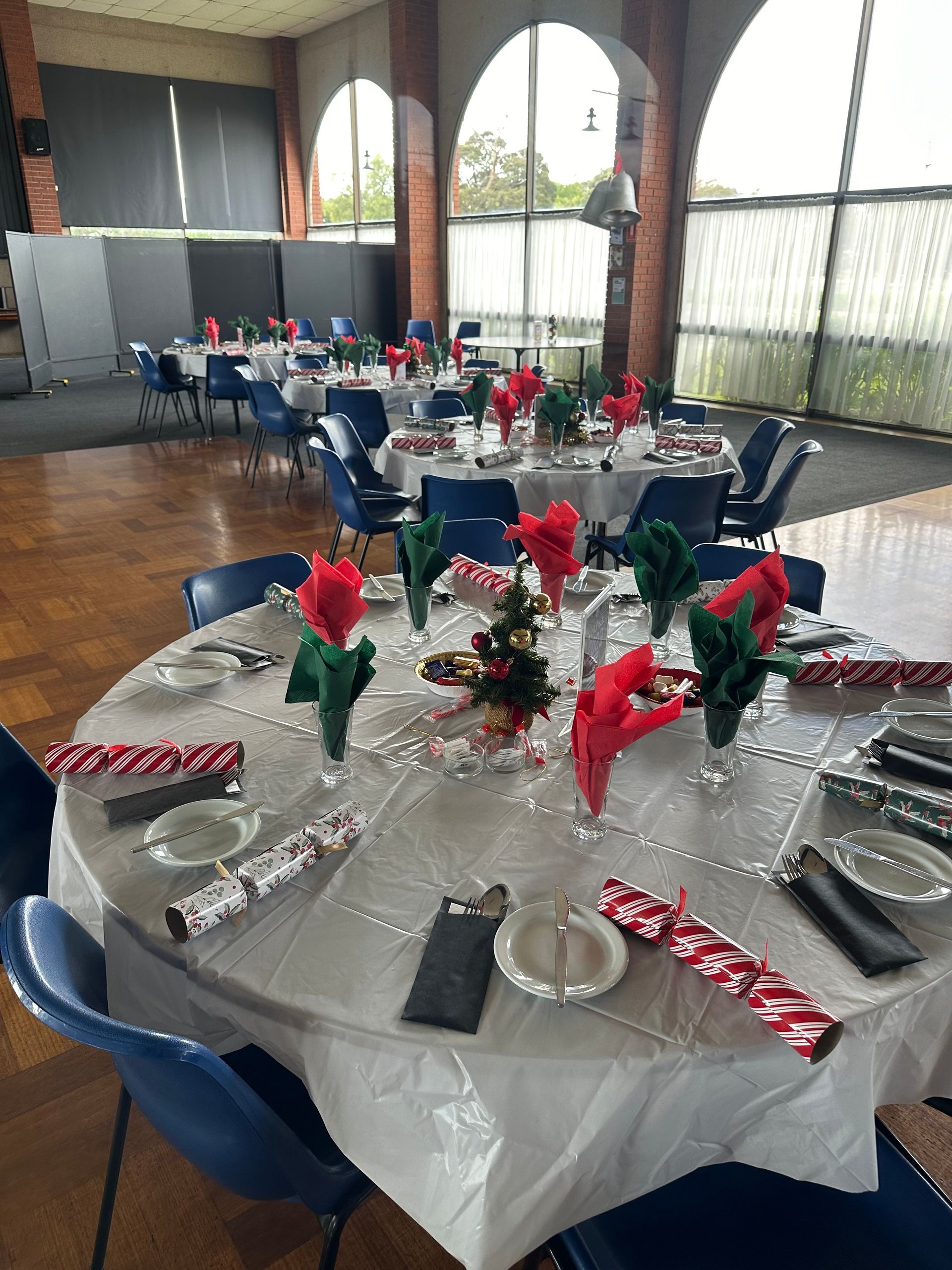 A large room with tables and chairs set up for a christmas party.