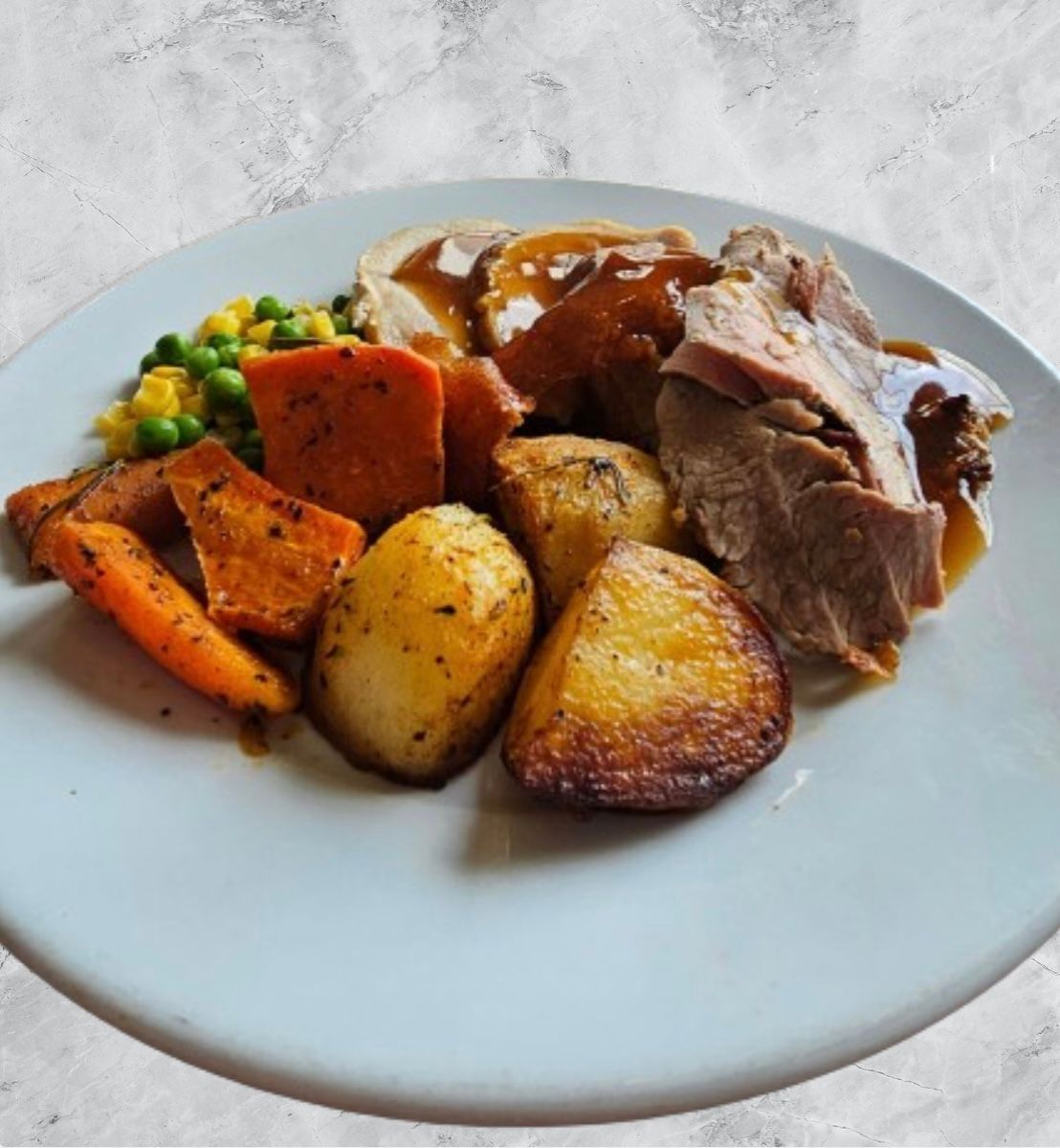 A white plate topped with meat potatoes carrots and peas