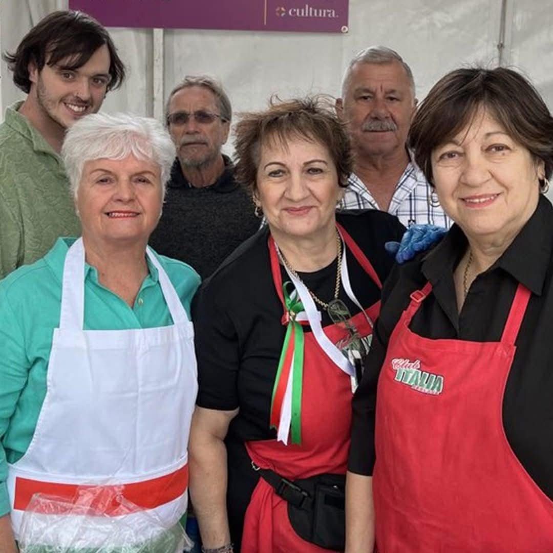 A group of people standing in front of a sign that says 5 cultures.