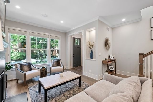 Living room with neutral tones, large windows, and modern furniture.