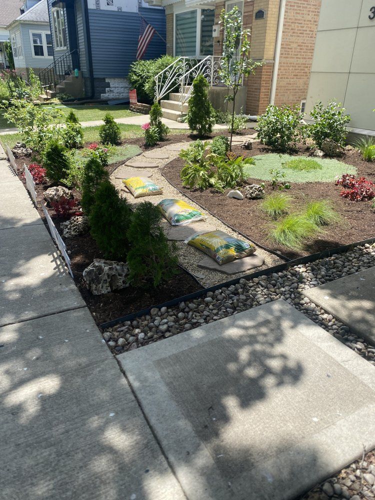 Landscaped front yard with a stone path, plants, and mulch borders a sidewalk.