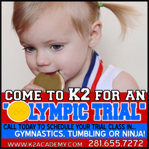 A little girl is holding a gold medal in her mouth and says come to k2 for an olympic trial