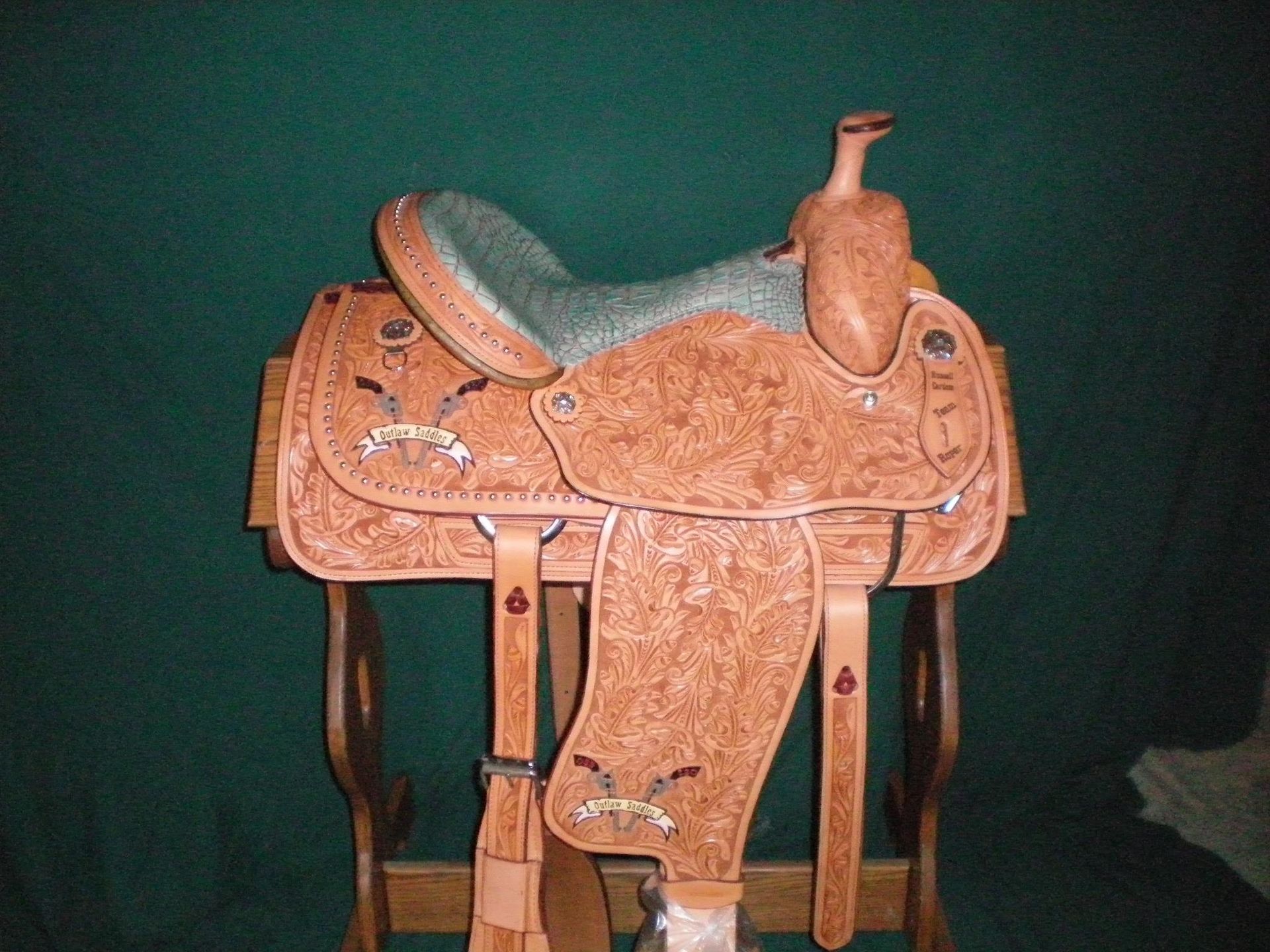 A brown saddle is sitting on a wooden stand