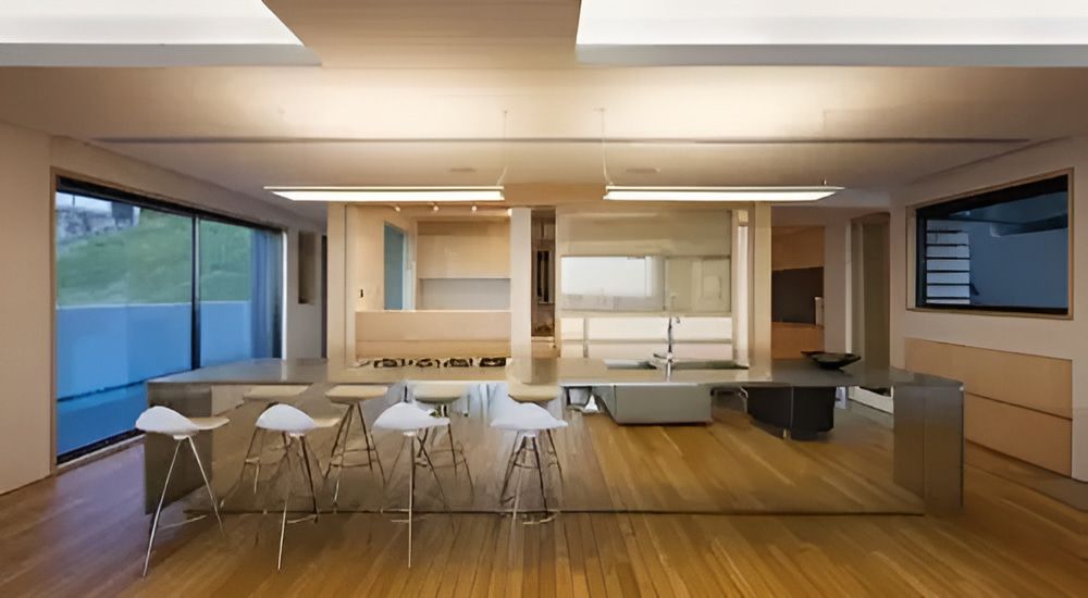 A Living Room With a Kitchen and a Table With Stools — Metaltrendz in Noosa, QLD
