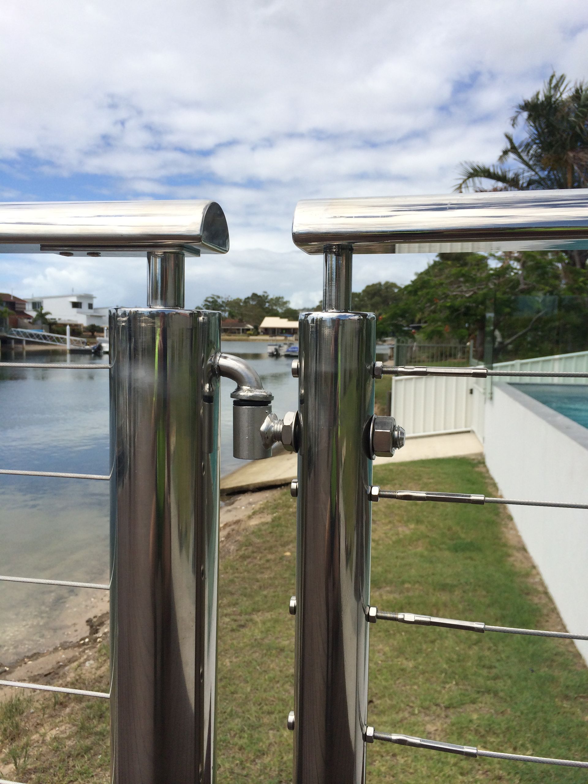 Stainless steel fence with cable lines, by a body of water — Metaltrendz in Kunda Park, QLD