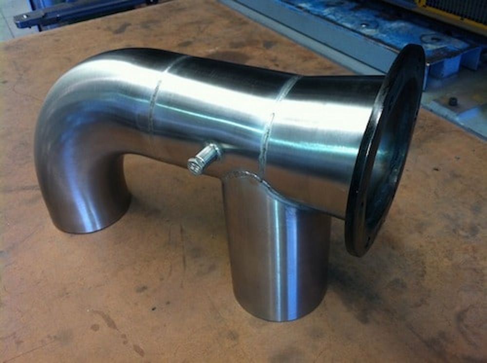 A Stainless Steel Pipe is Sitting on a Wooden Table — Metaltrendz in Coolum Beach, QLD