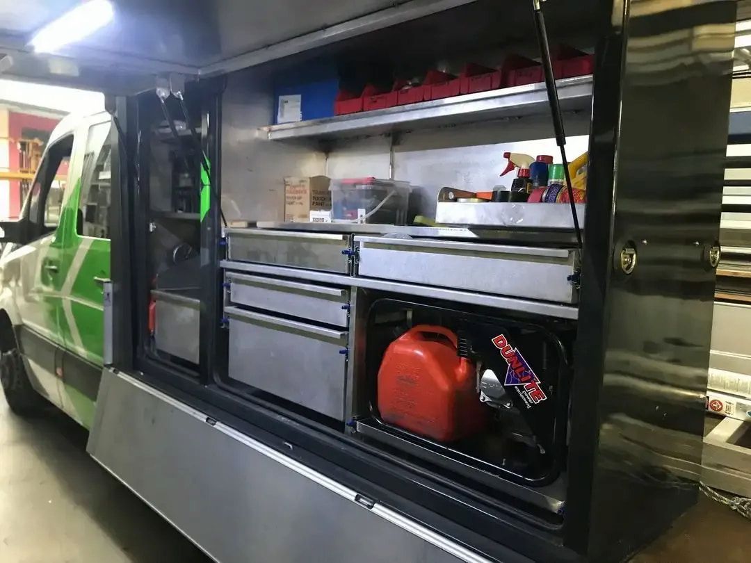 A Green and Black Van is Parked in a Garage With Shelves and Drawers — Metaltrendz in Buderim, QLD