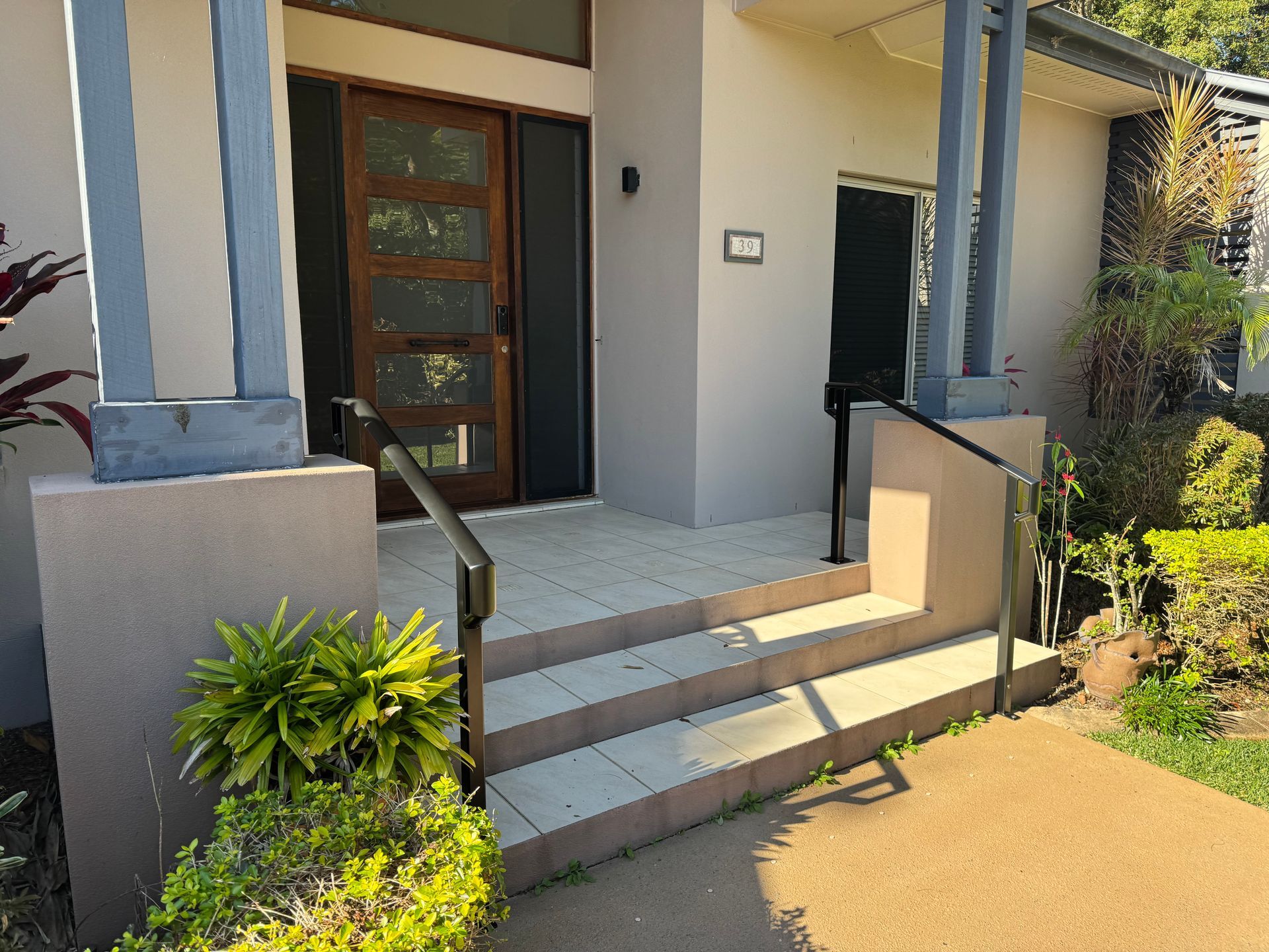 Exterior view of a light gray home with steps leading to the front door — Metaltrendz in Kunda Park, QLD