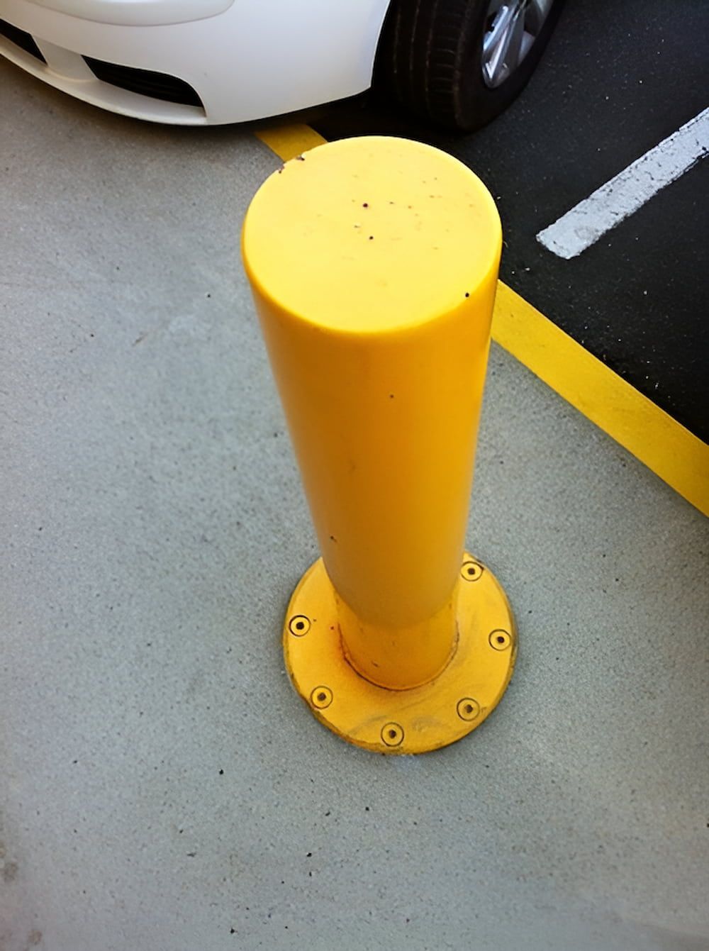 A Yellow Pole in a Parking Lot Next to a White Car — Metaltrendz in Kunda Park, QLD