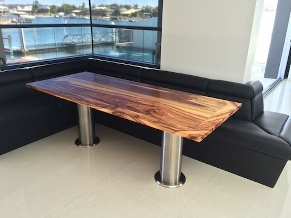 A Wooden Table is Sitting Next to a Black Couch in a Living Room — Metaltrendz in Kunda Park, QLD
