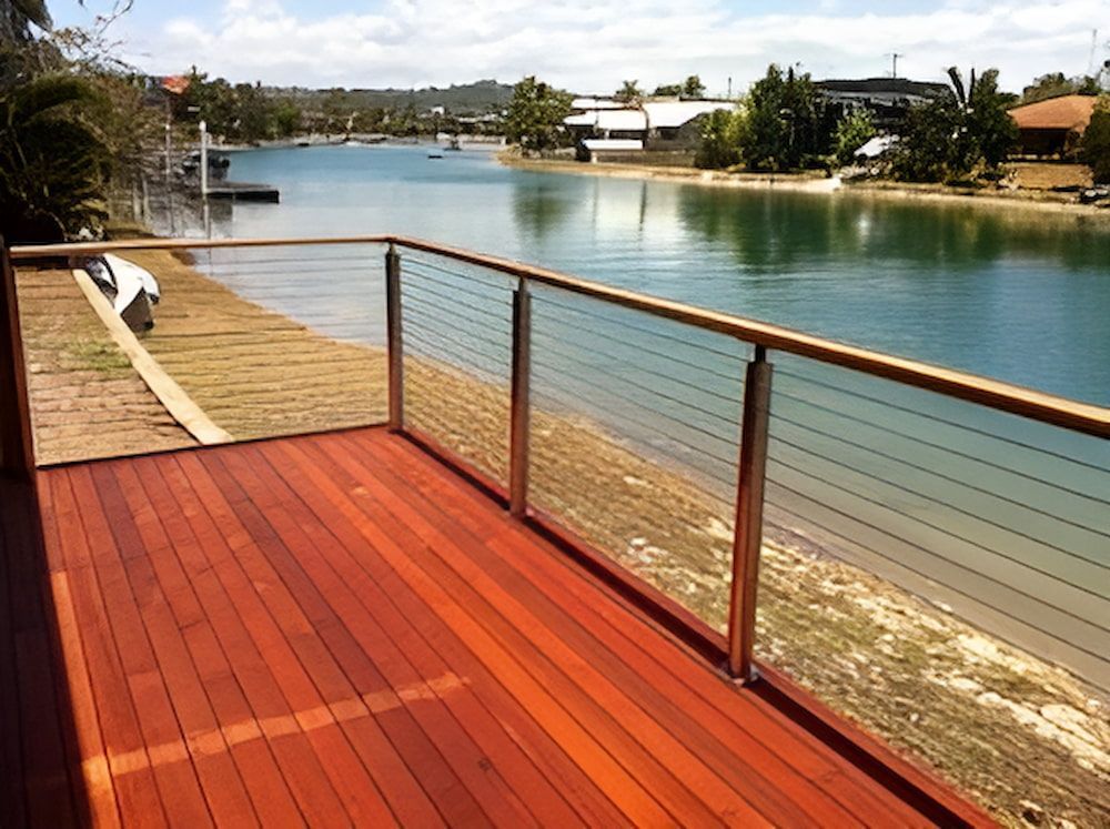 A Wooden Deck With a Stainless Steel Railing Overlooking a Body of Water — Metaltrendz in Kunda Park, QLD