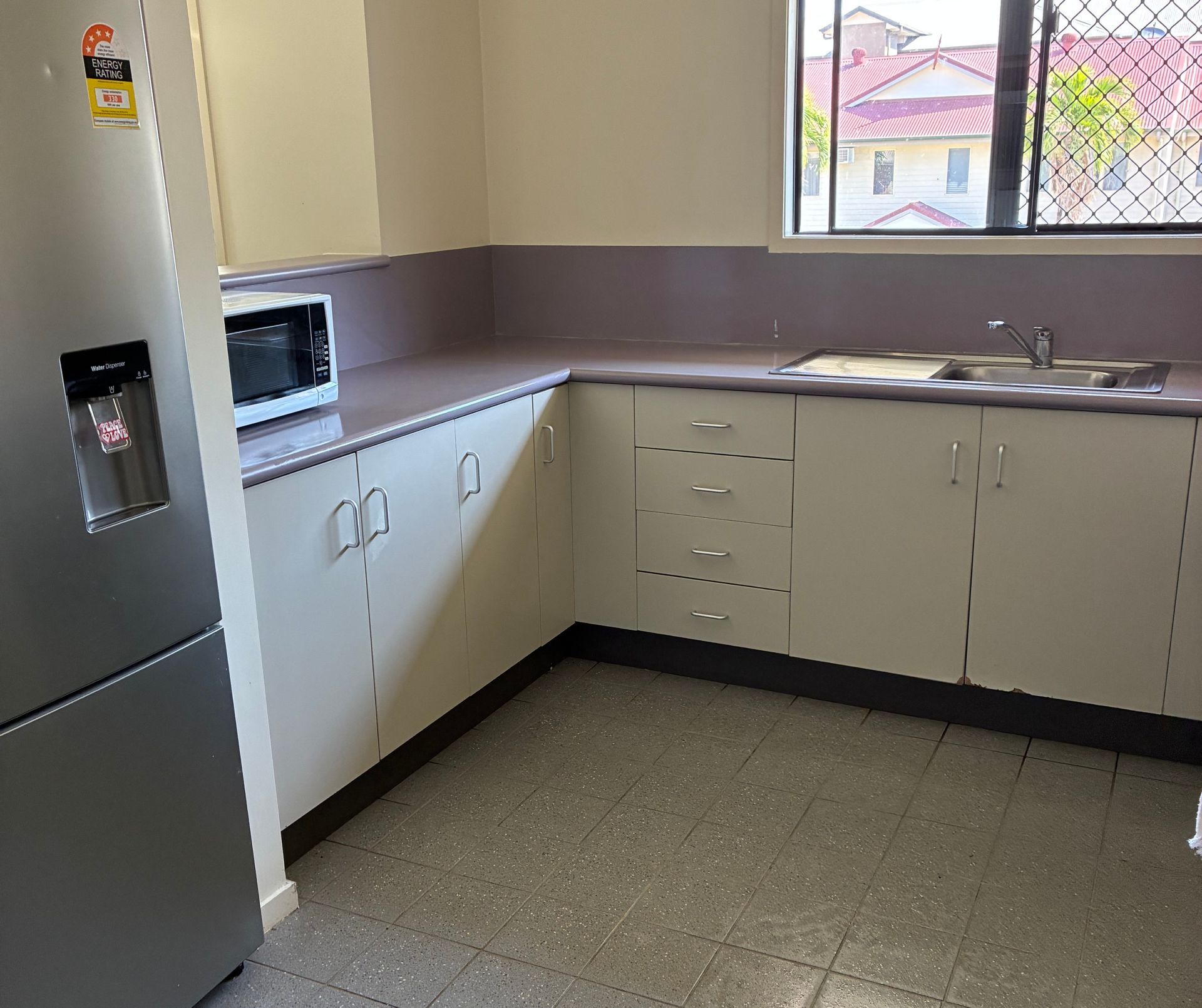 Kitchen With White Cabinets, Lilac Countertops, and a Gray Speckled Floor — Schmucker Cleaning in Gulliver, QLD