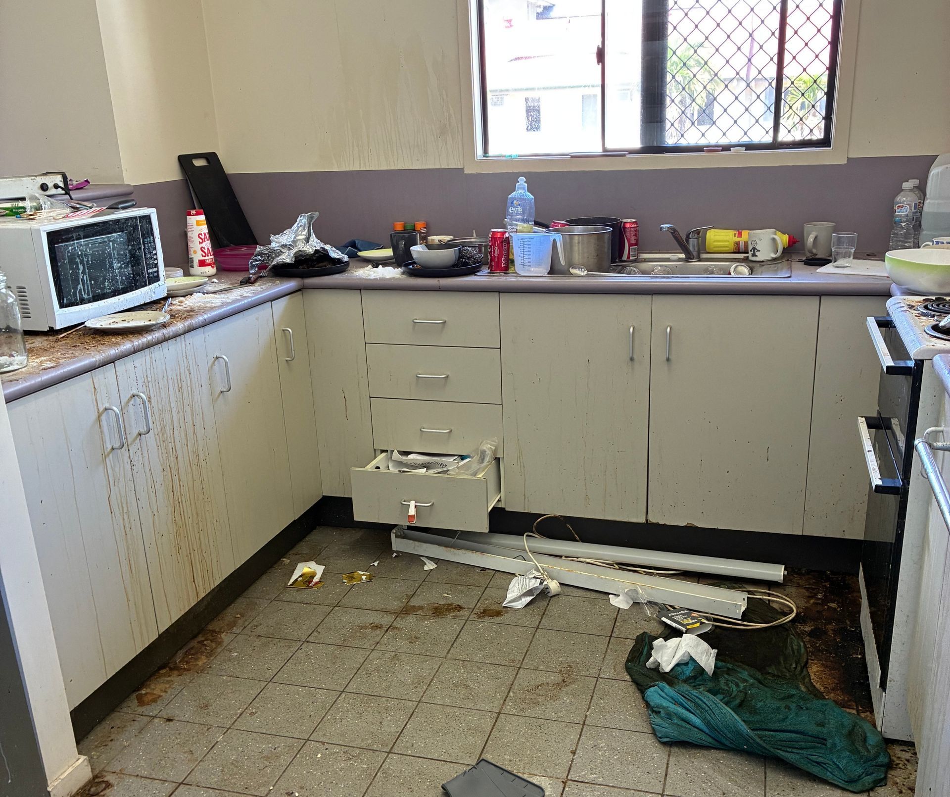 Spilled Food and Debris on Floor, Cluttered Counter With Microwave  — Schmucker Cleaning in Gulliver, QLD