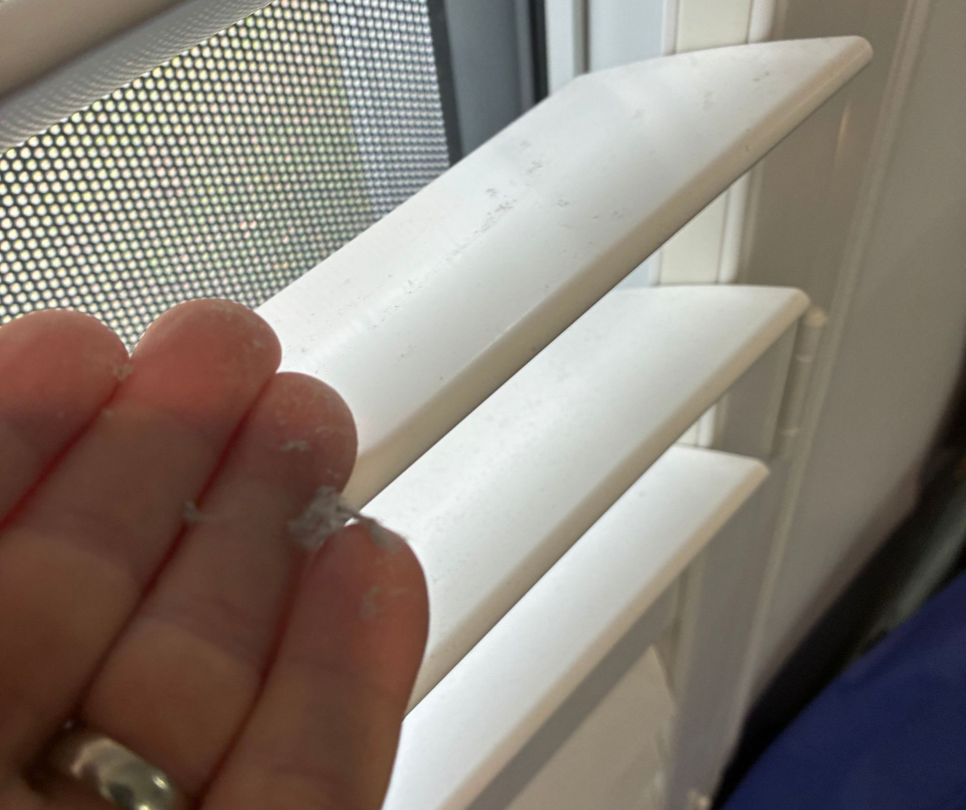 Hand Holding a Dusty, White Fiber, With White Window Blinds in the Background — Schmucker Cleaning in Gulliver, QLD