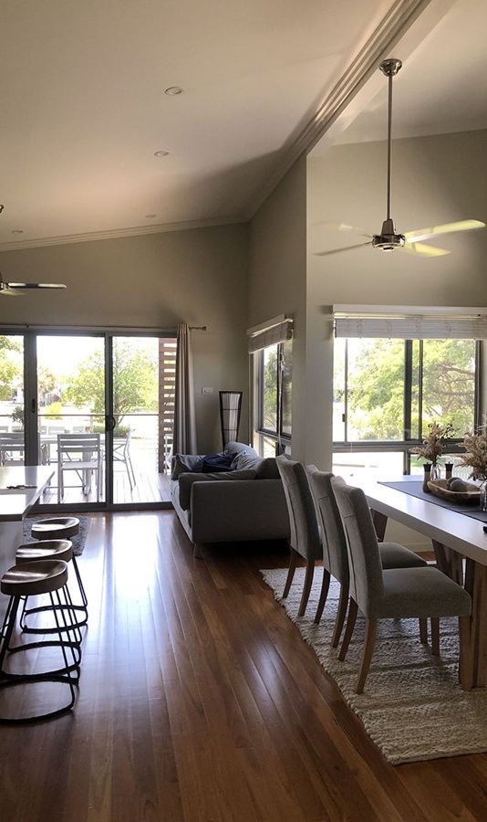 A Living Room With a Couch, Table and Chairs and a Ceiling Fan — Schmucker Cleaning in Gulliver, QLD