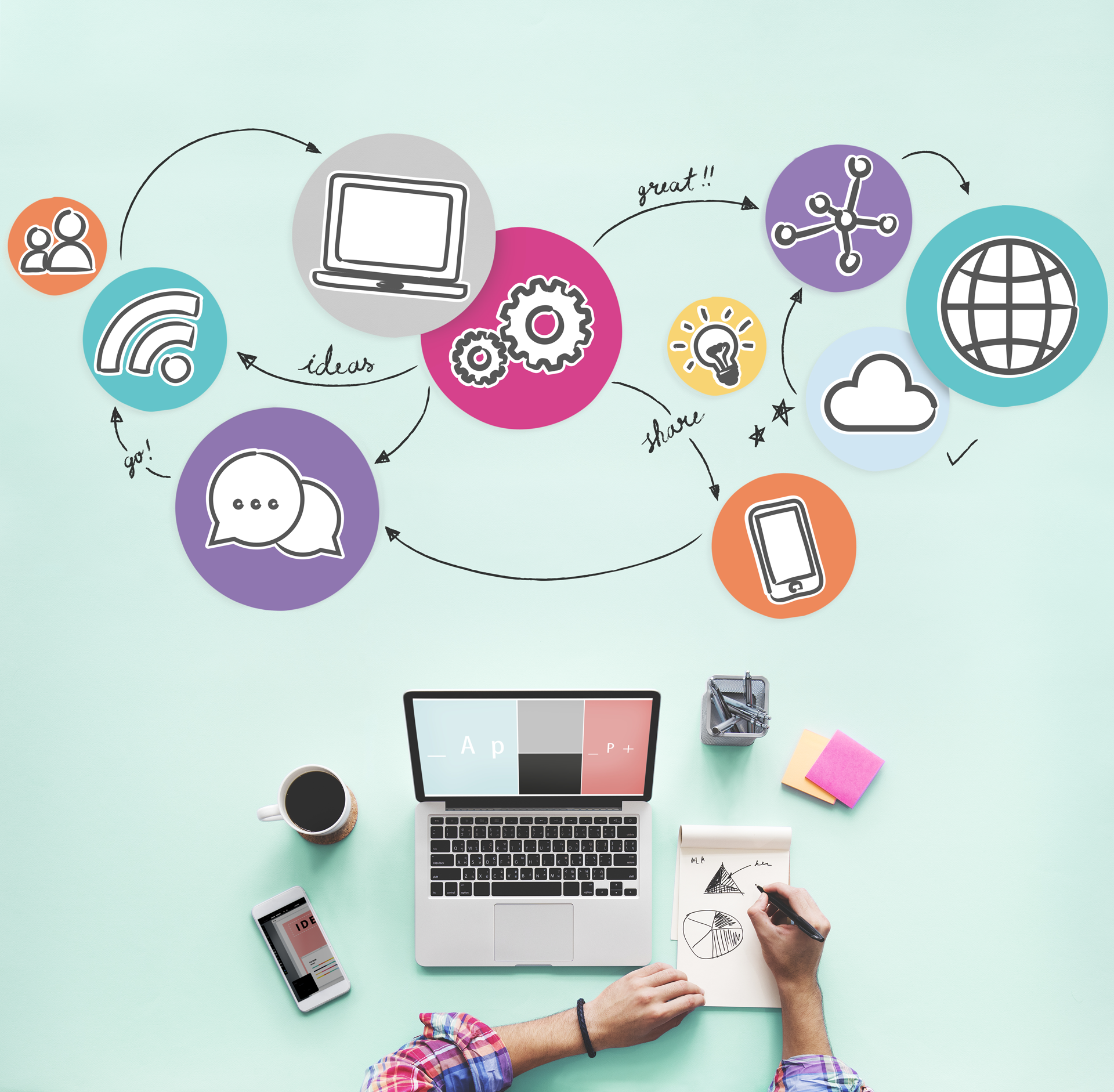 A person is sitting at a desk with a laptop and a notebook.