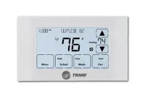 White Trane thermostat with digital display showing 76°F. Buttons for menu, heat, cool, and fan.