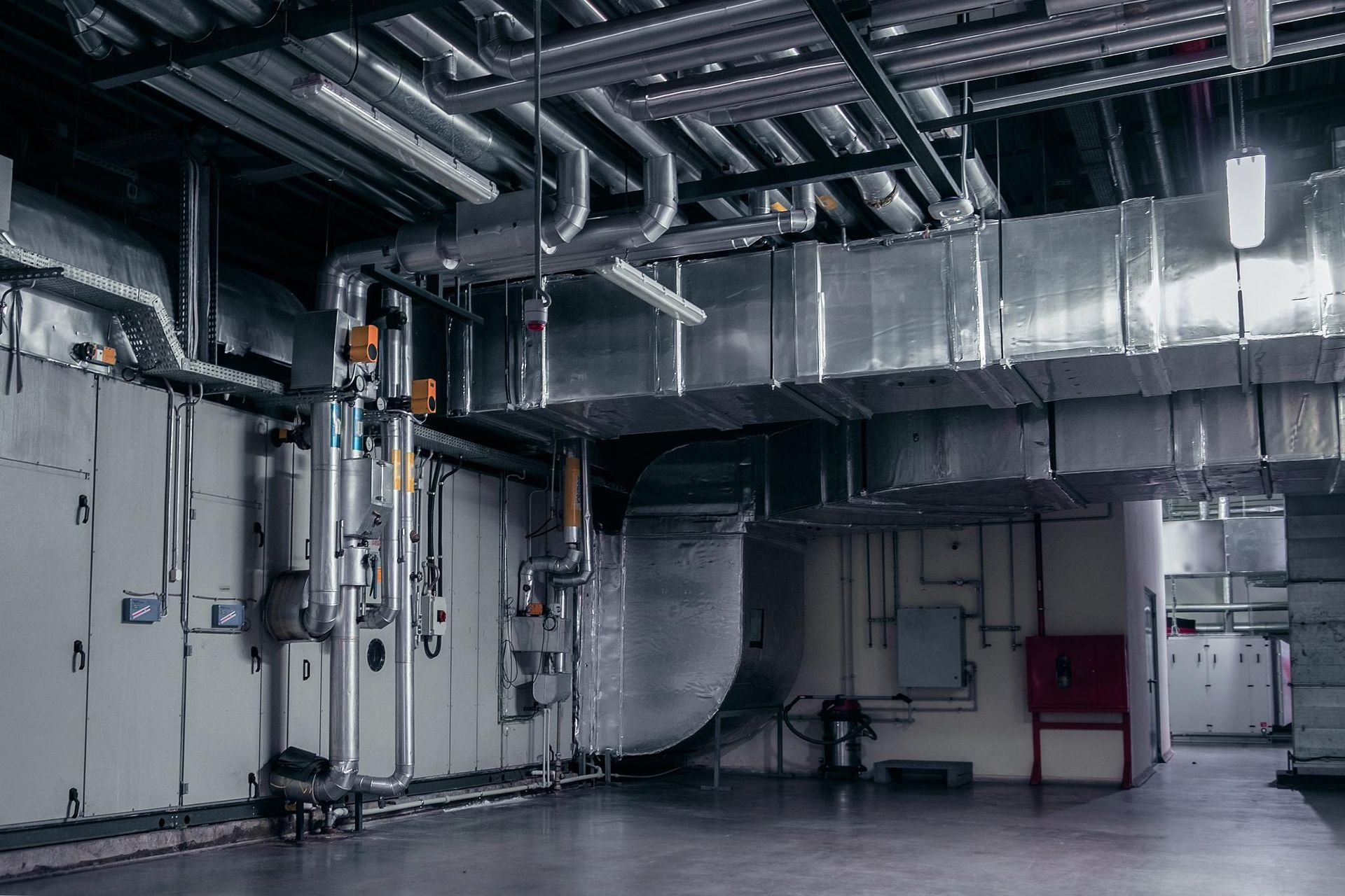 Large industrial space with HVAC system and metallic ducts.
