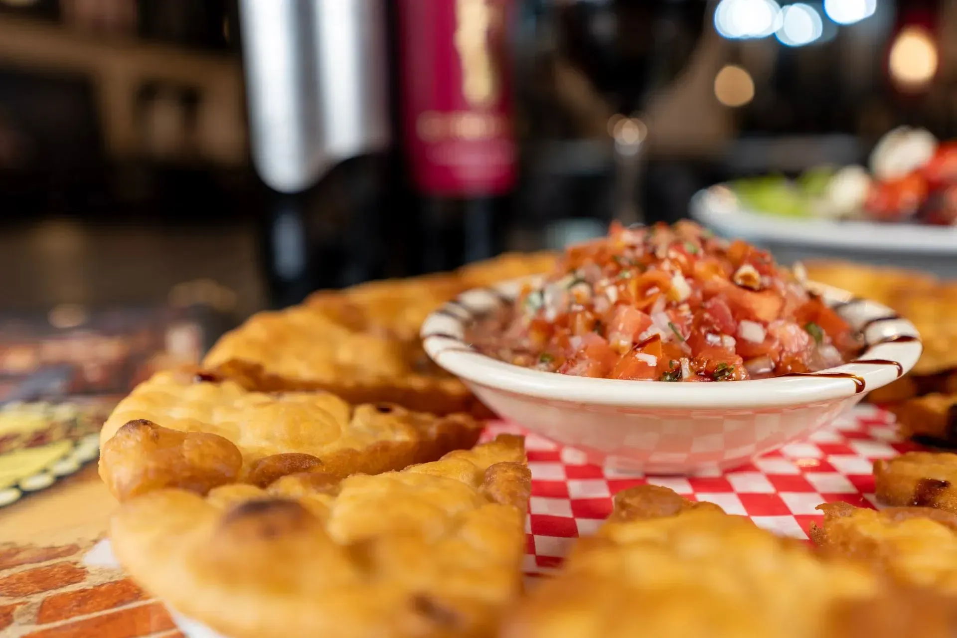 A close up of a plate of food with a bowl of salsa on a table.