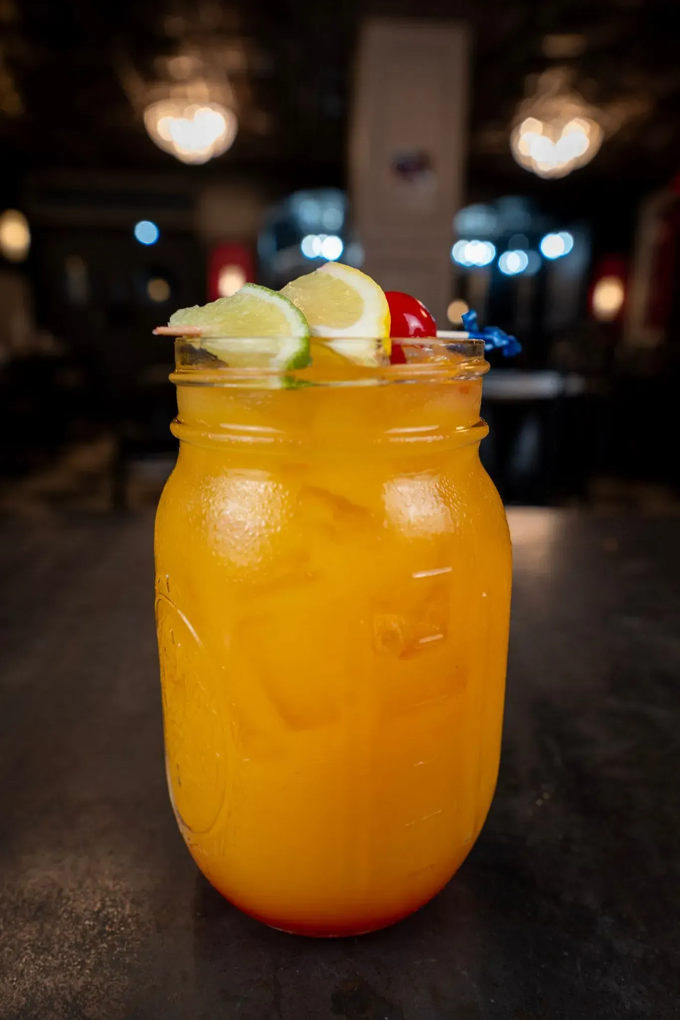 A close up of a drink in a mason jar on a table.