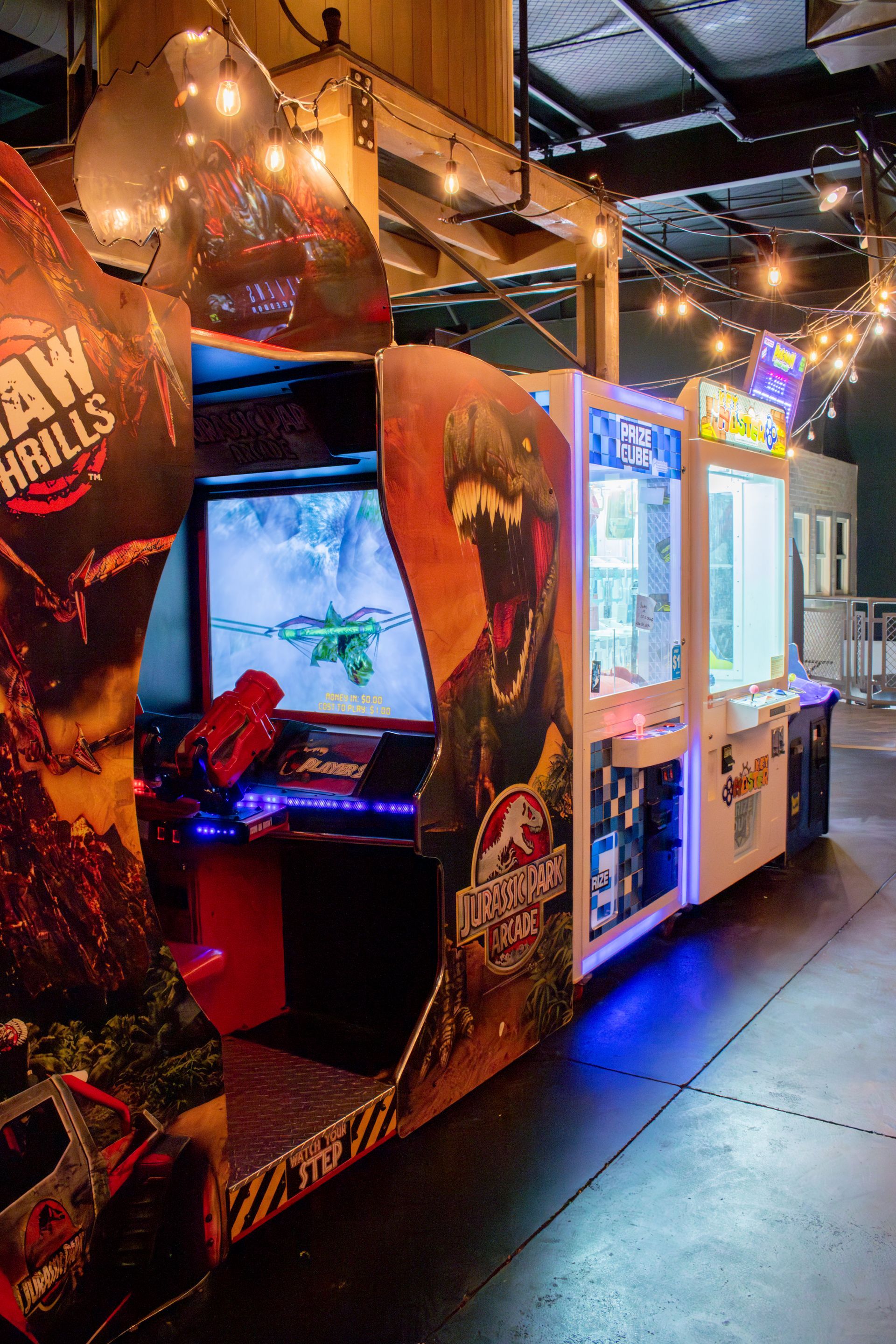 A bunch of arcade games are lined up in a room.