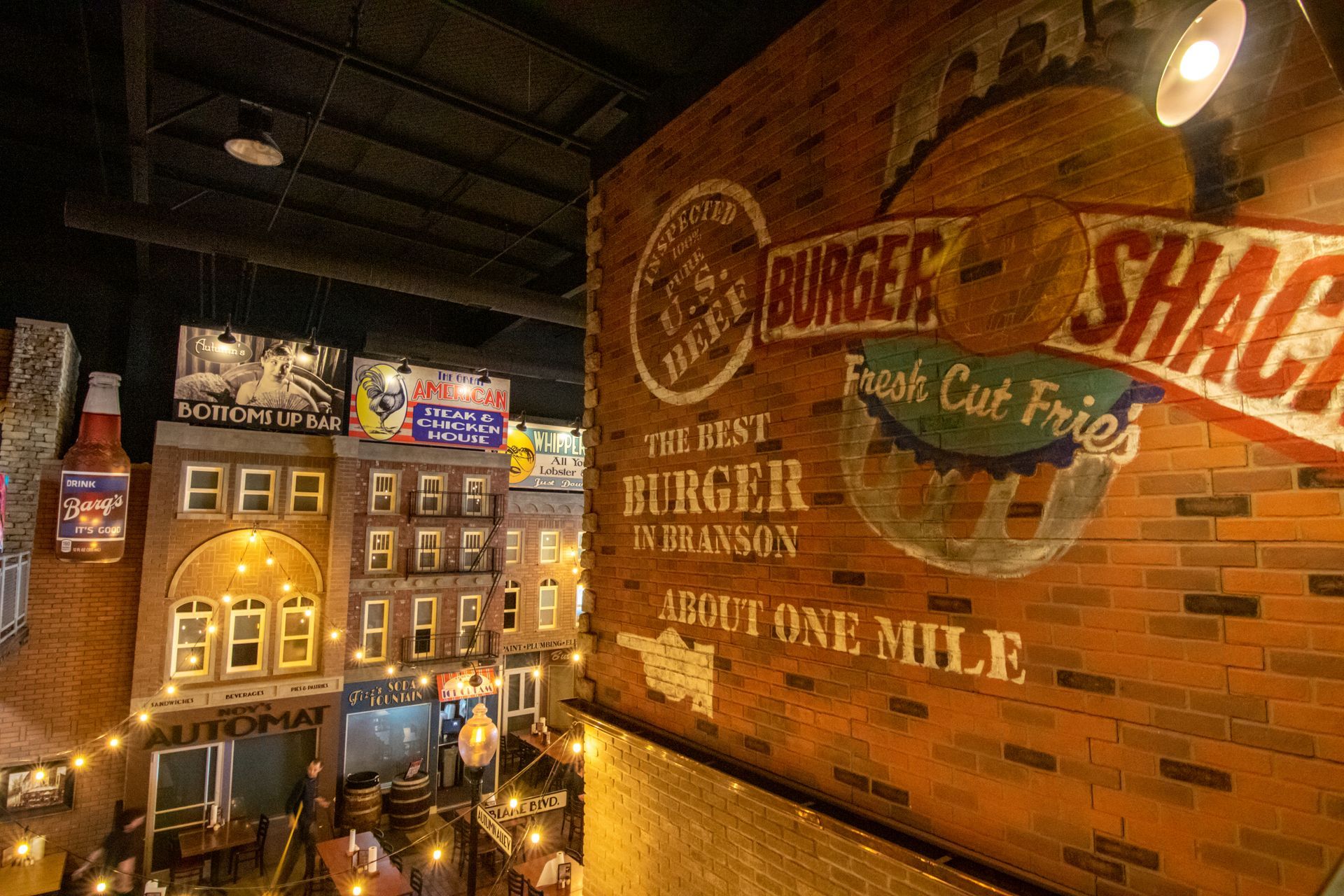 A restaurant with a brick wall and a sign that says `` burger shack ''.