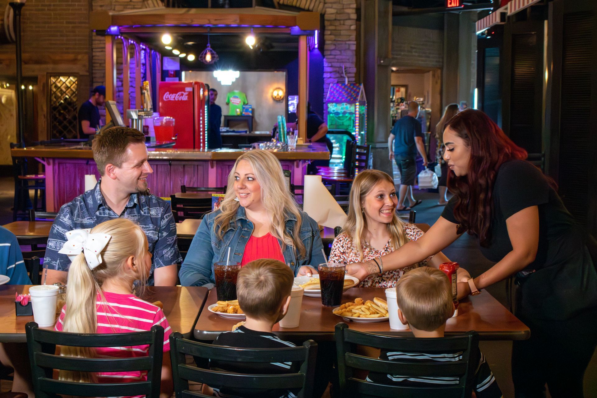 A group of people are sitting at a table in a restaurant eating food.