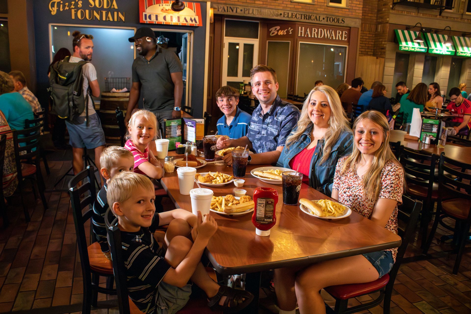 A family is sitting at a table in a restaurant eating food.
