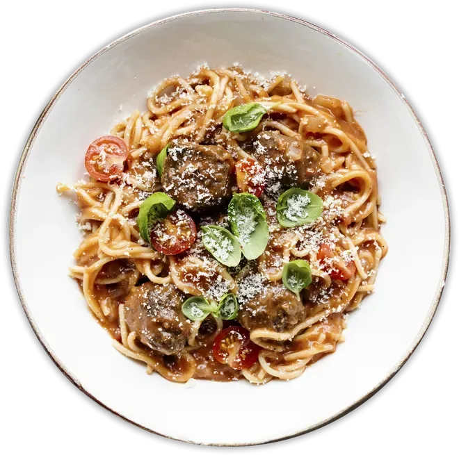 A plate of spaghetti with meatballs and tomatoes on a white background.