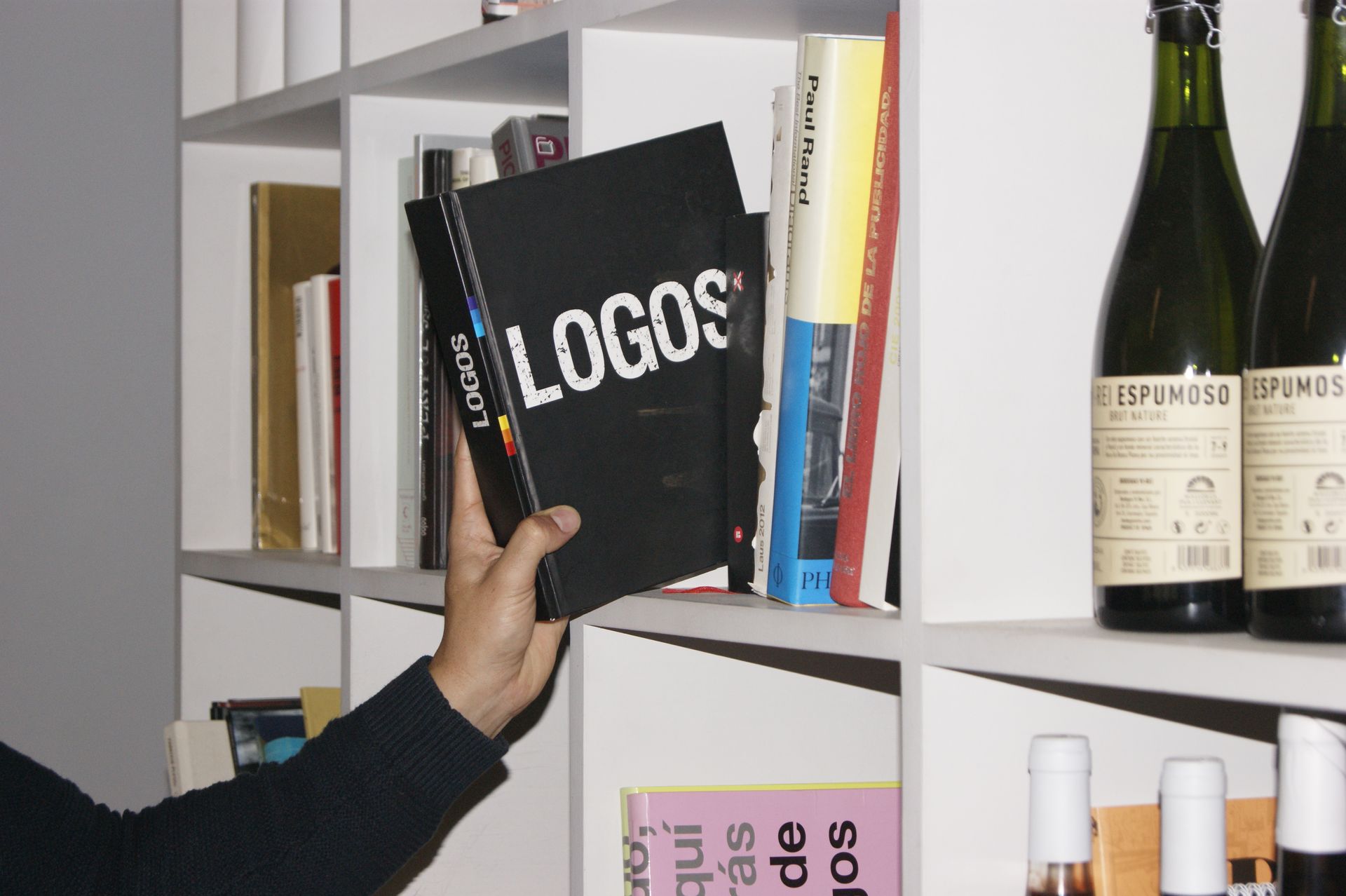 Sala d'estar amb sofà seccional marró, taula de centre de pedra i parets taronges.