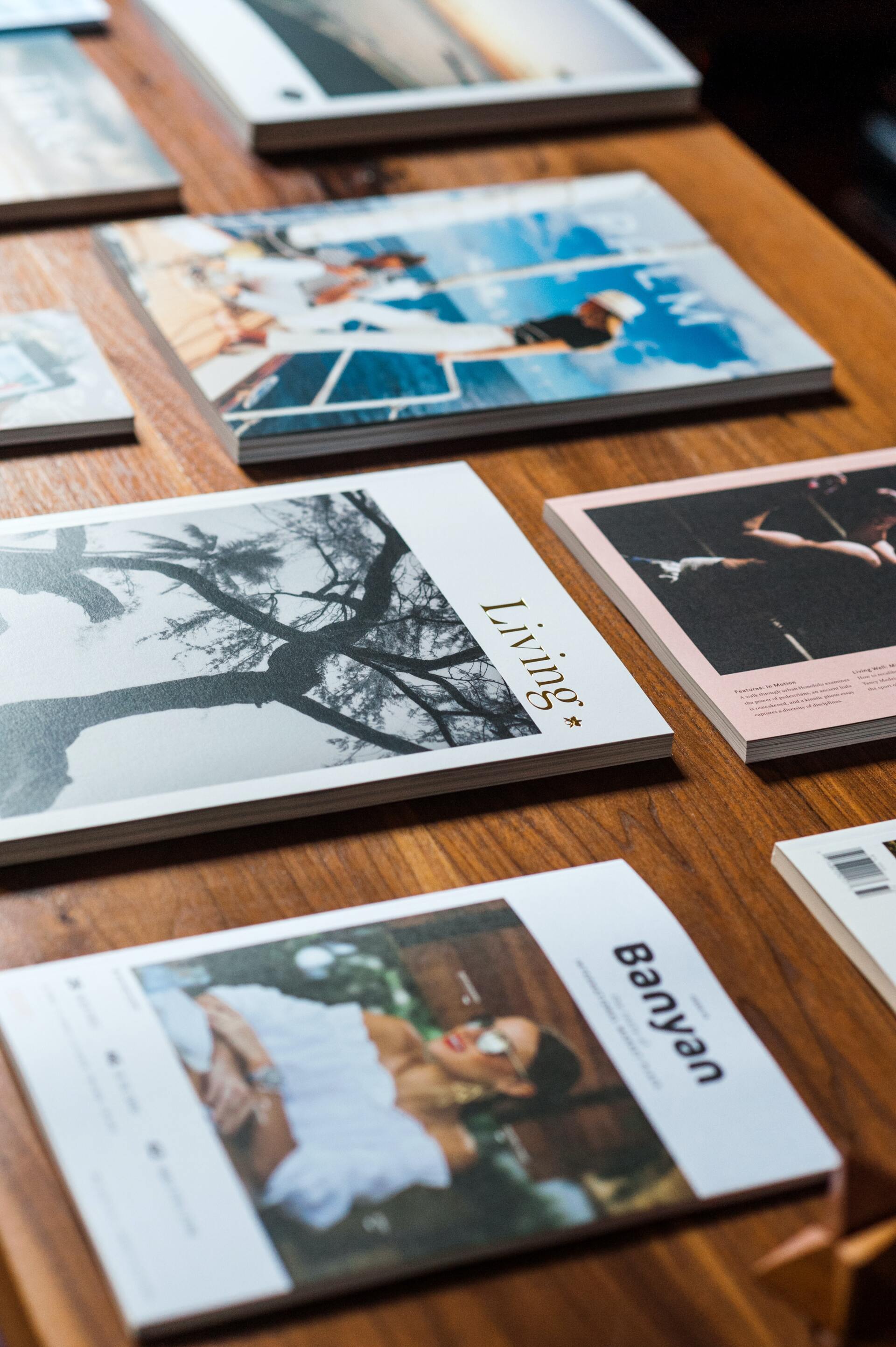 A bunch of magazines are sitting on a wooden table