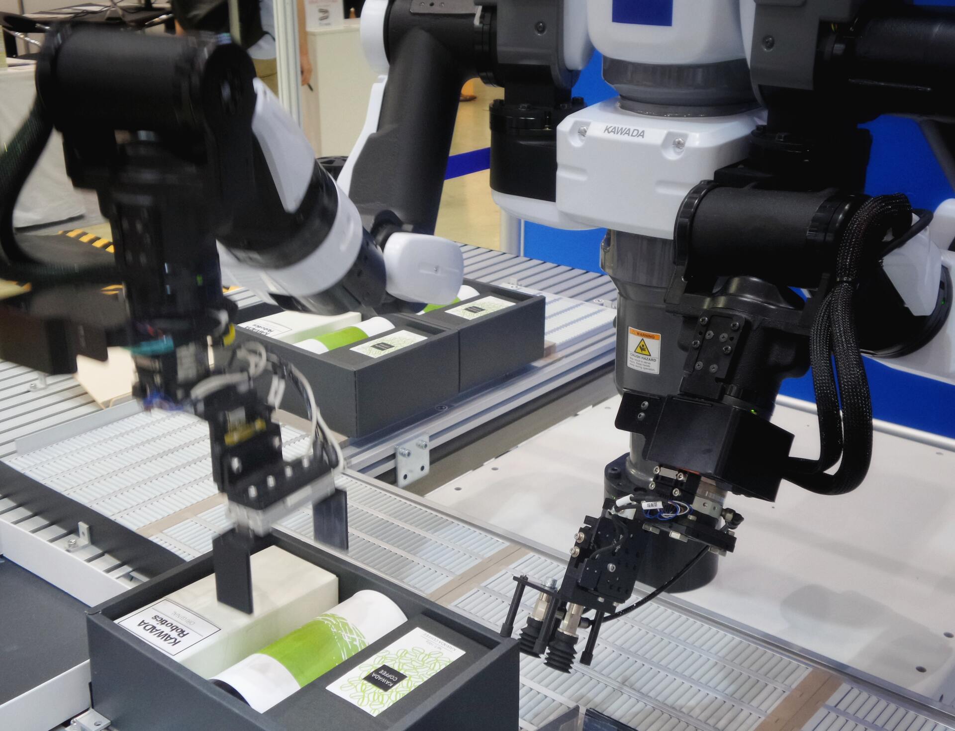 Two robots are working on a conveyor belt in a factory.