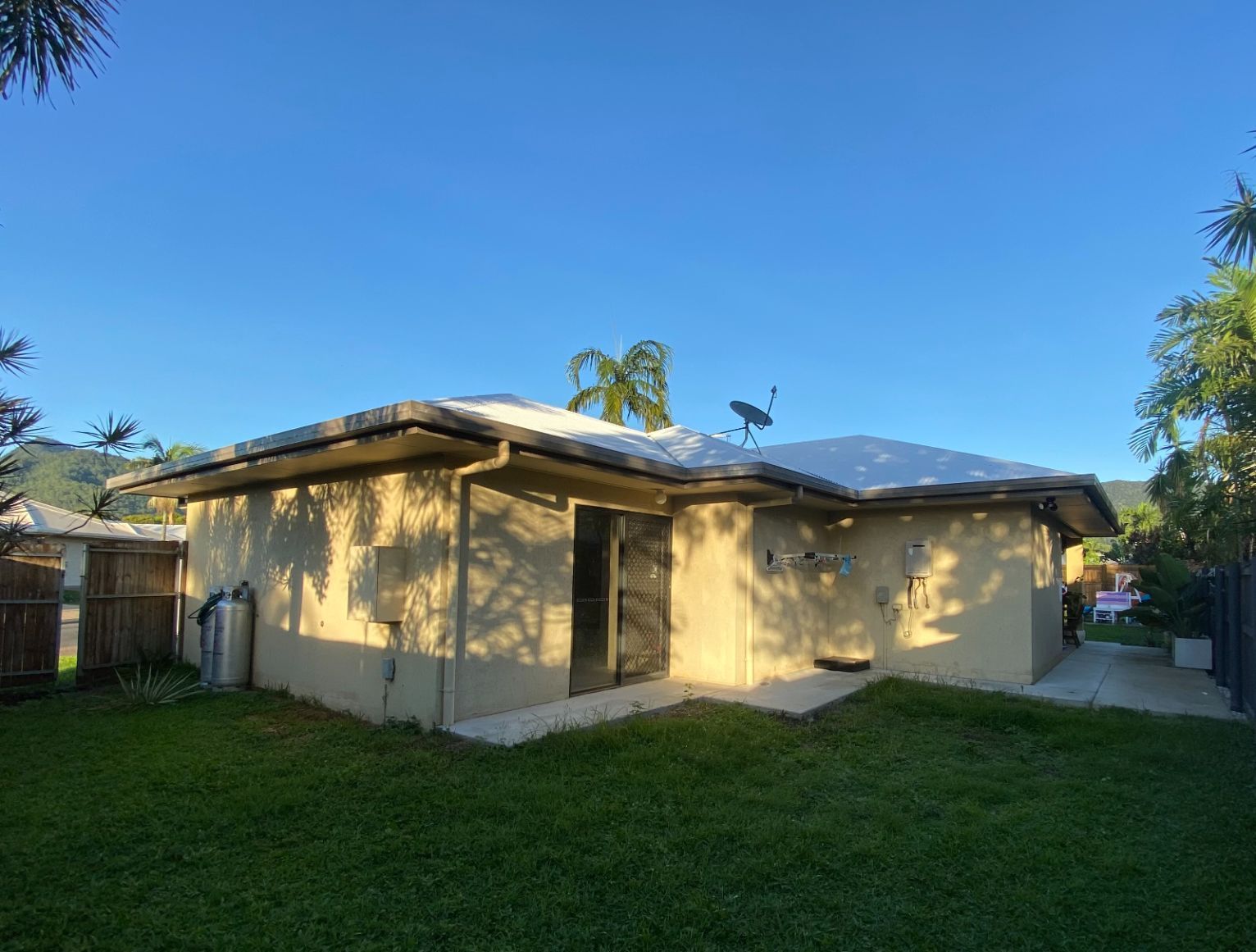 A White House with A Green Backyard Lawn — Painting & Maintenance FNQ Handyman Service in Clifton Beach, QLD