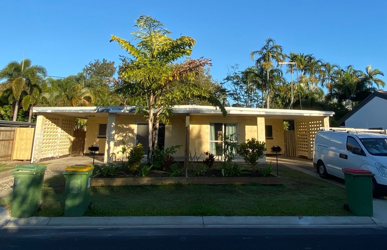 A White House with A Green Gutter and A Palm Tree in Front of It — Painting & Maintenance FNQ Handyman Service in Clifton Beach, QLD