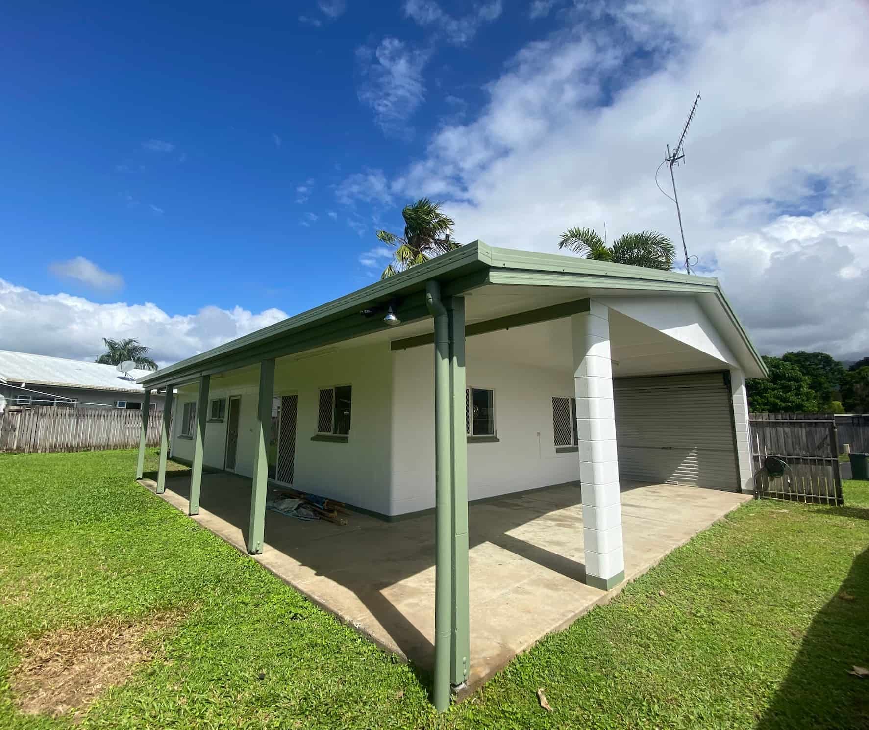 A White House With a Green Porch and a Blue Sky in the Background — Painting & Maintenance FNQ Handyman Service in Clifton Beach, QLD