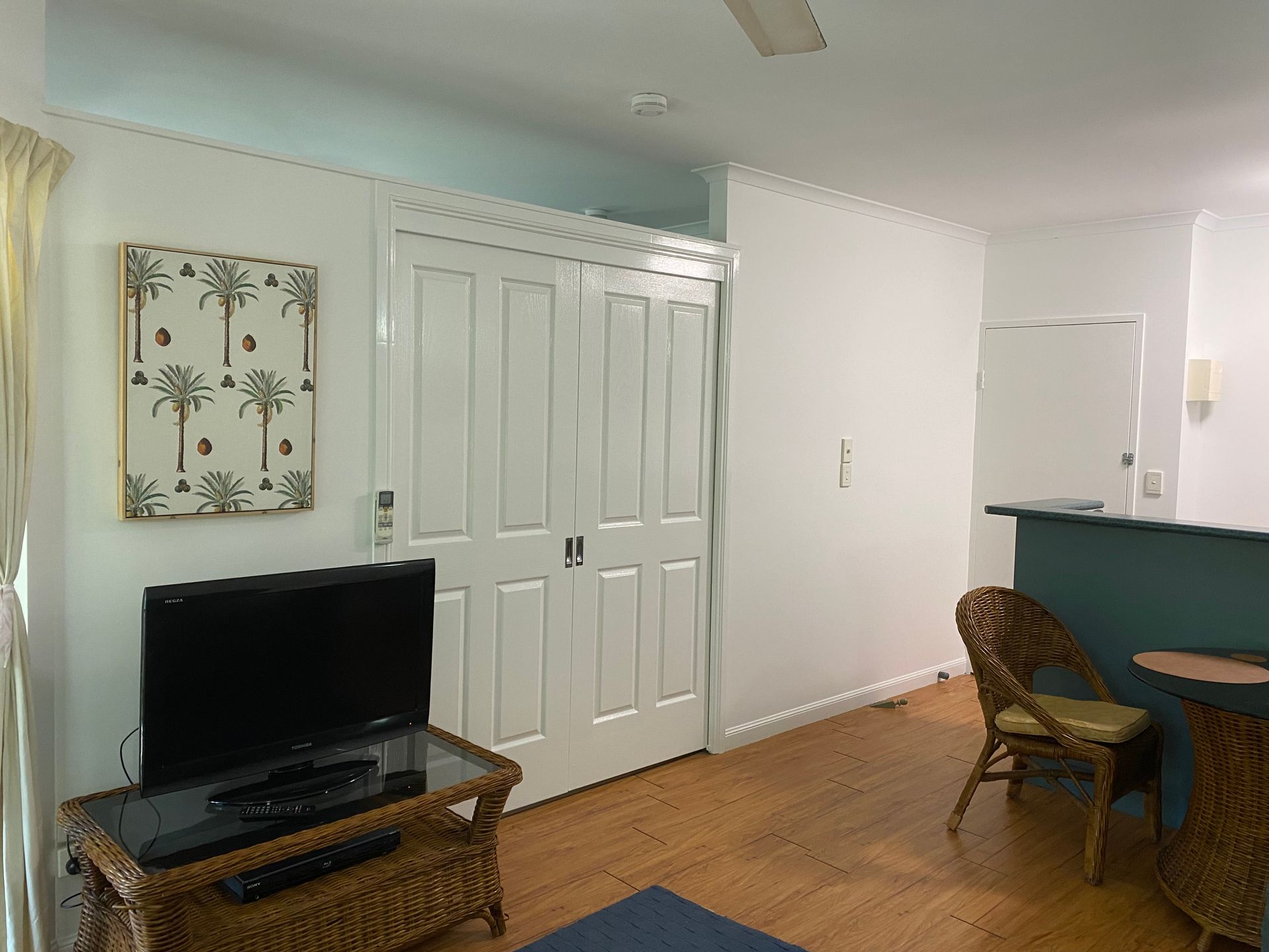 A Living Room With a Flat Screen Tv on a Wicker Stand — Painting & Maintenance FNQ Handyman Service in Clifton Beach, QLD