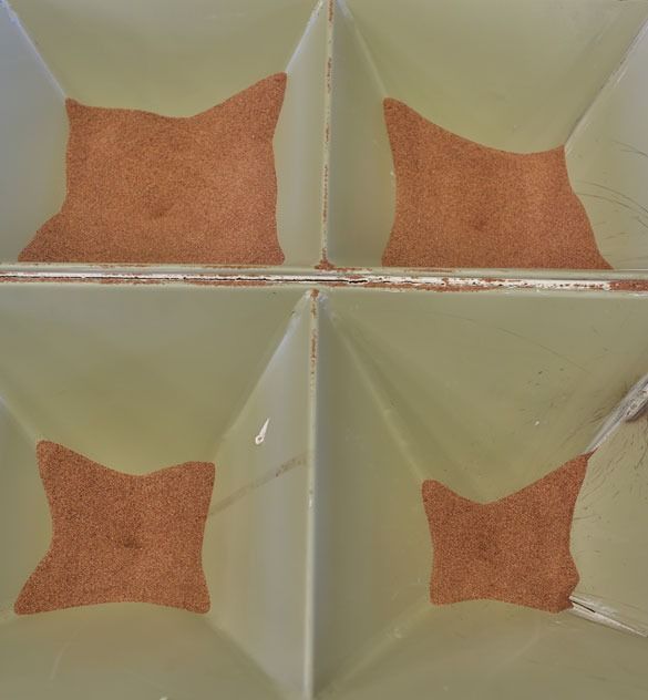 Four square bins with orange granular material inside, arranged in a 2x2 grid.