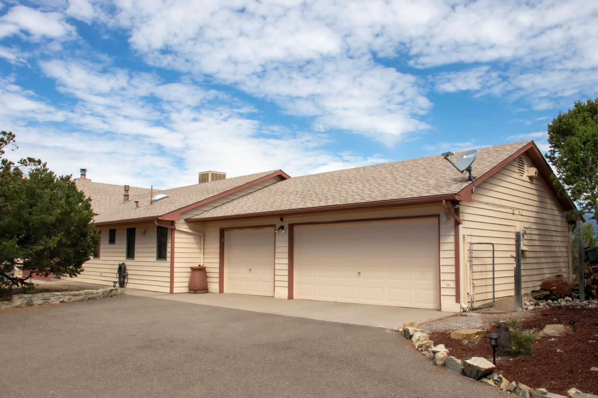 a house with two garage doors and a satellite dish on the roof