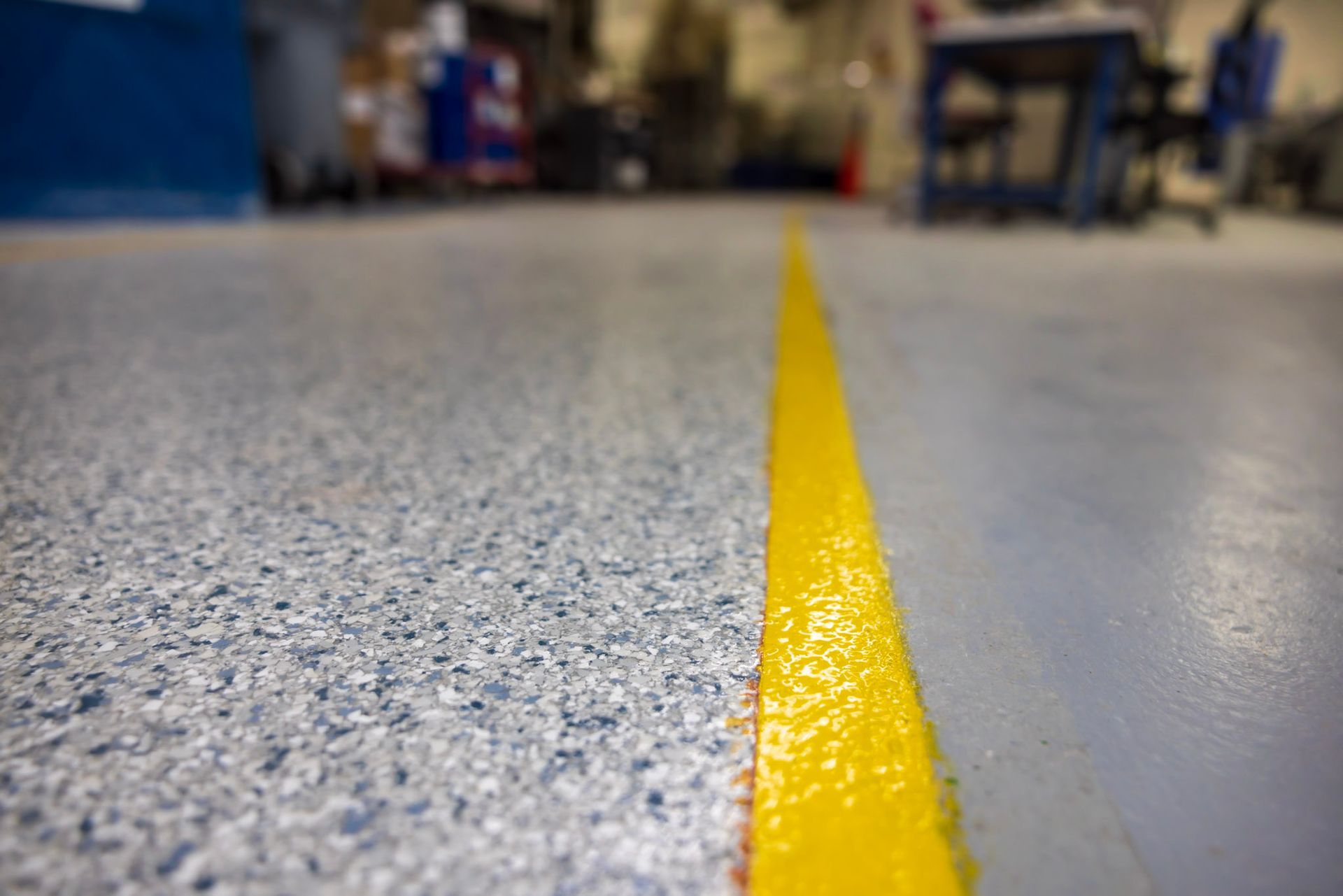 a yellow line is painted on the floor of a warehouse .