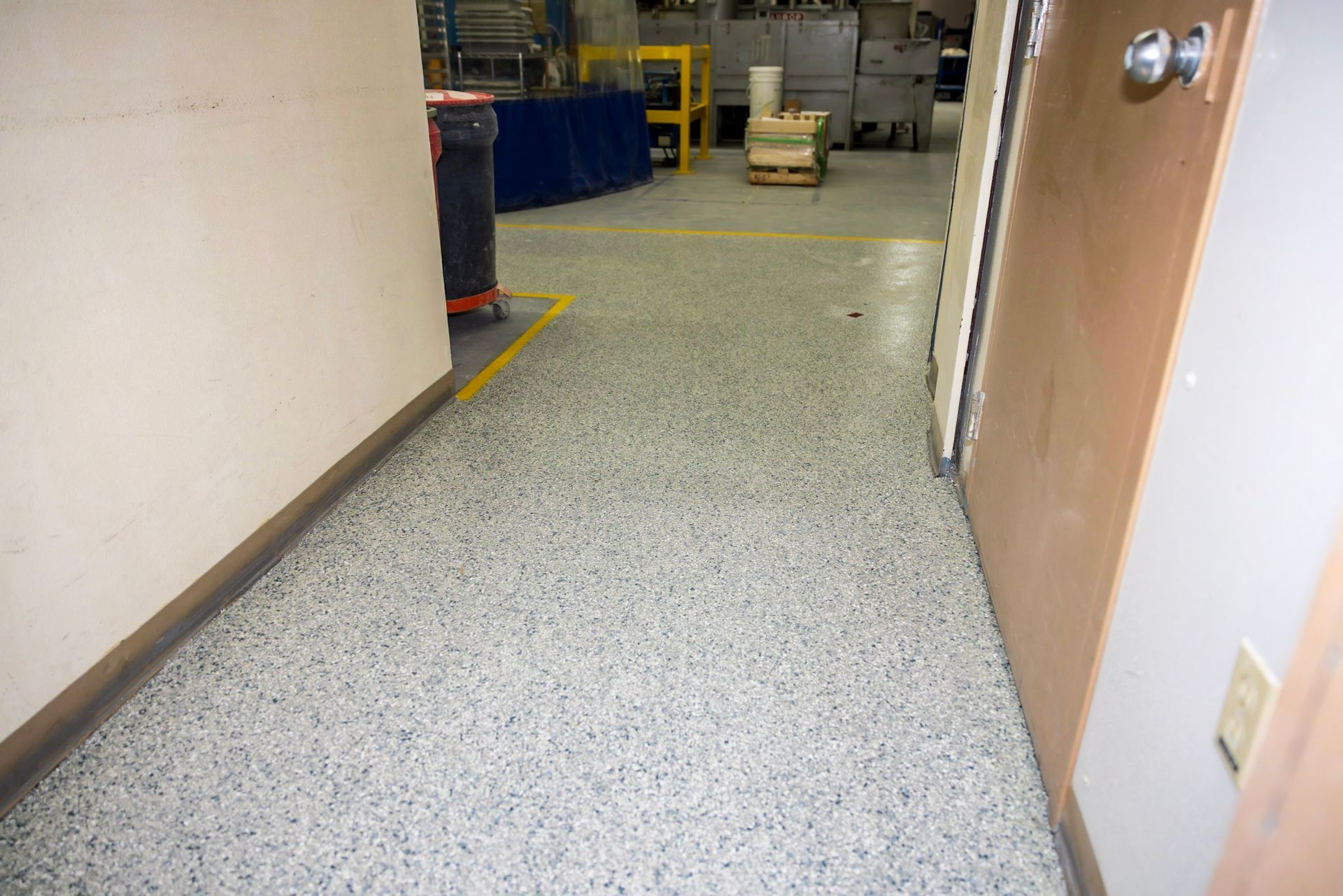a hallway with a concrete floor and a door