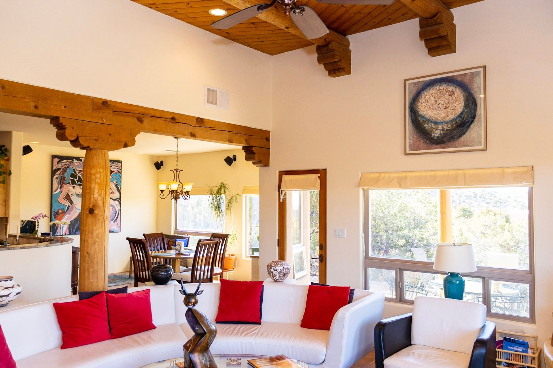 a living room with a white couch and red pillows