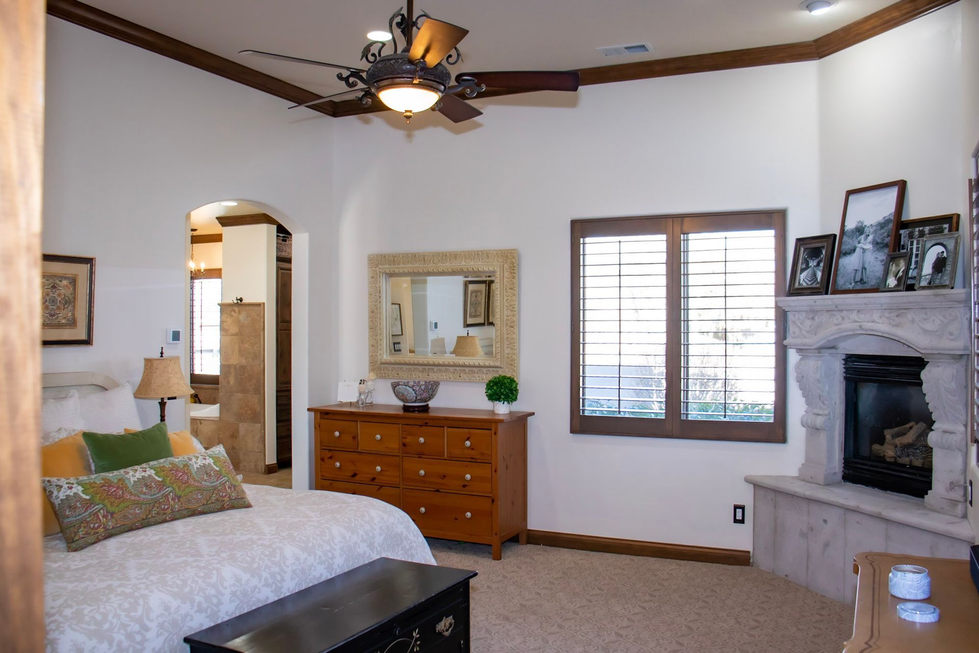 a bedroom with a fireplace and a ceiling fan