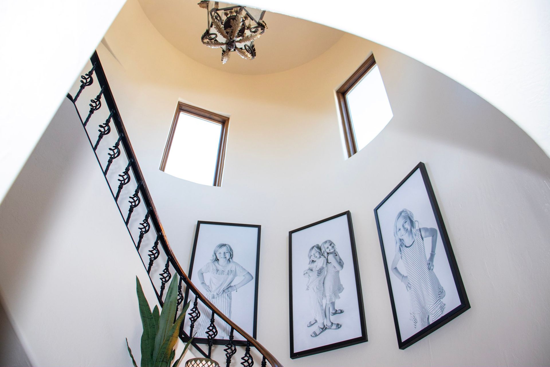 a spiral staircase with three framed pictures on the wall