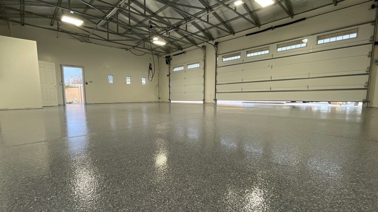 a large empty garage with a garage door open and a shiny floor .