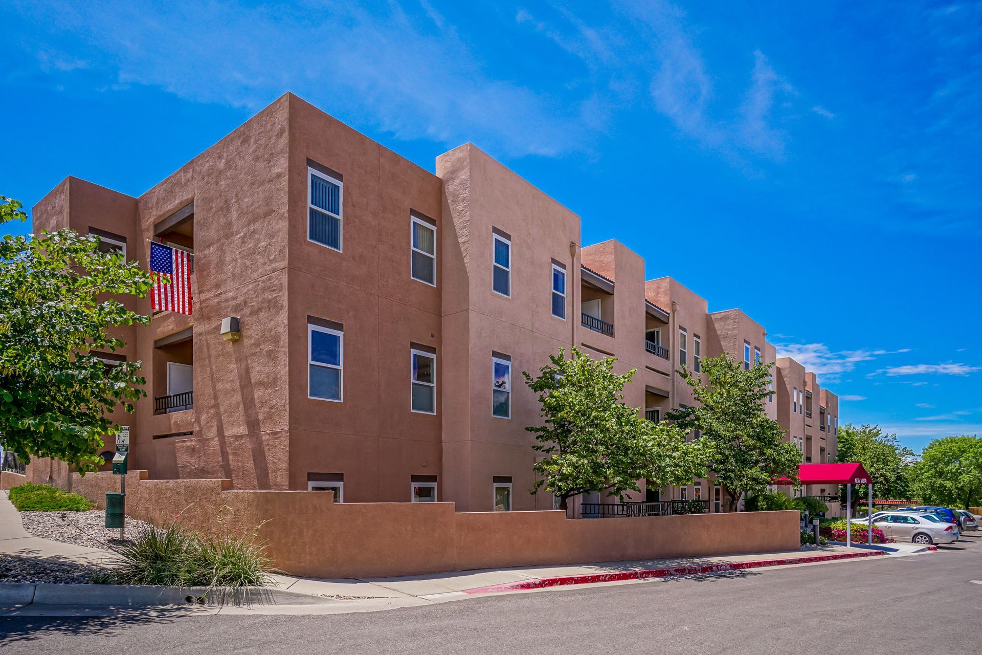 a large apartment building with a red awning on the side of it .