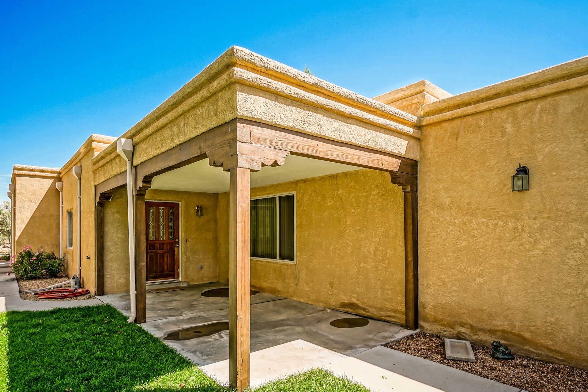a house with a covered porch and a lawn in front of it .
